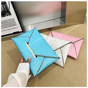 Gros plan de trois pochettes enveloppes colorées avec motifs d'étoiles et bordure dorée