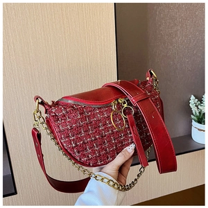 Detail of red tweed shoulder bag showing gold chain strap and large ring zipper puller