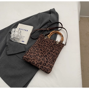 Dettaglio della borsa shopper leopardata con manico in bambù e tracolla in pelle regolabile