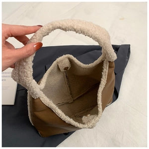 Dettaglio dello scomparto interno con chiusura magnetica dorata sulla borsa a mano