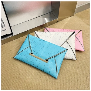 Détail de trois pochettes enveloppes en bleu, blanc et rose avec motifs d'étoiles argentées