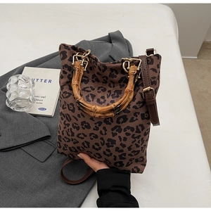 Dettaglio borsa shopper leopardata con manico in bambù e finiture in metallo oro