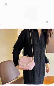 Pink tweed metal frame bag with large pearl handle and fine gold chain strap detailing
