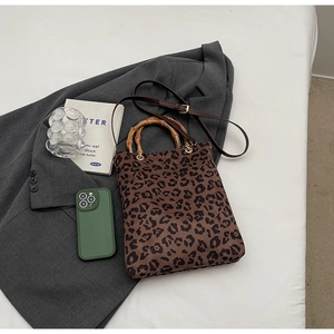 Dettaglio borsa tote leopardata con manici in bambù naturale e tracolla sottile rimovibile