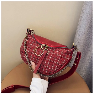 Detail of red tweed saddle bag featuring golden ring zippers and leather shoulder strap