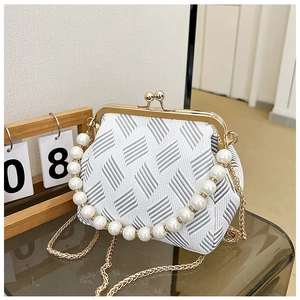 Detail of vintage frame bag with jacquard pattern, large pearl handle and gold chain strap