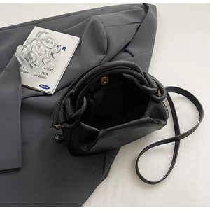 Dettaglio della borsa a nuvola nera a pieghe con chiusura magnetica dorata