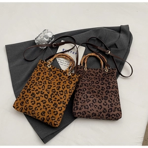 Vista dettagliata delle borse tote leopardate con manici in bambù e tracolle regolabili