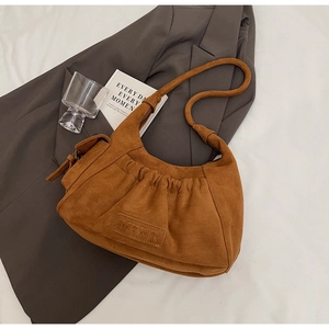 Detail view of brown suede tote bag featuring pleated texture and DAYMIX leather logo patch