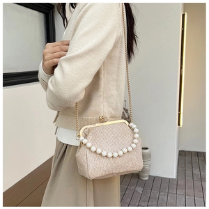Detail of vintage champagne sequin crossbody bag with pearl handle worn by a model