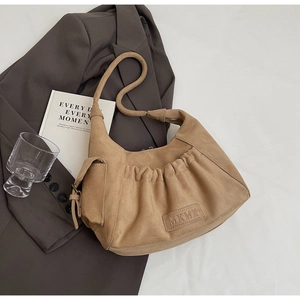 Detail view of khaki suede tote bag featuring pleated design and side pocket detail