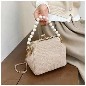 Detail view of champagne gold glitter evening bag with pearl handle and metal clasp