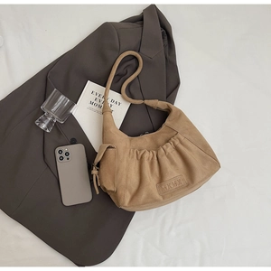 Detailed view of the camel suede tote bag with textured folds and MKMX embossed logo