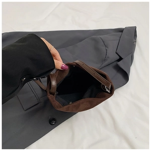 Vue intérieure du sac seau marron mat avec doublure noire et poche zippée pratique