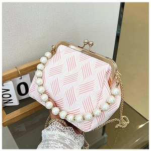 Detail of pink and white striped woven bag with pearl handle and gold clasp