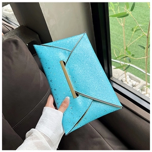Détail d'une pochette enveloppe à paillettes bleu vif avec étoiles argentées et barre