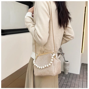 Detail of champagne gold sequin evening bag with large pearl handle and metal chain