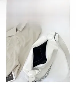 Détail du sac à bandoulière en cuir blanc brillant avec grande capacité et poches
