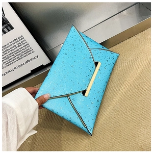 Détail de la pochette enveloppe bleu vif avec motifs d'étoiles argentées et fermoir doré