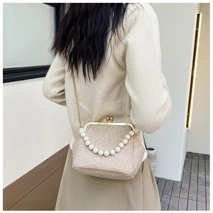 Detail view of champagne gold woven evening bag with pearl handle and metal chain strap