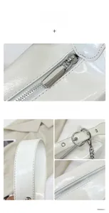 Détail d'un sac en cuir verni blanc avec fermeture éclair argentée et anneau à chaîne