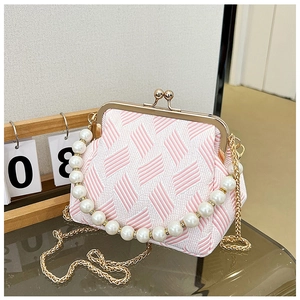 Detailed view of vintage fabric kiss-lock bag with pearl handle and gold chain strap