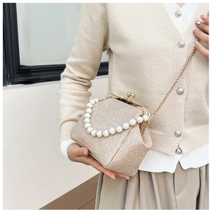 Detail of champagne gold sequin bag with pearl handle and metal chain shoulder strap