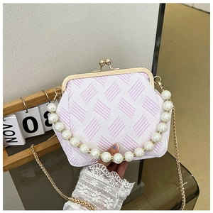 Detail of pink and white pattern handbag with pearl handle and gold clasp closure