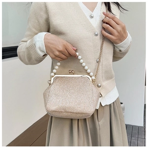 Detail of vintage champagne gold purse with pearl handle and metal clasp closure