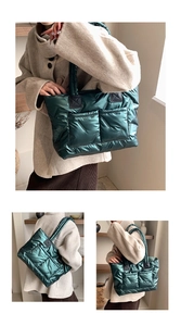 Detail of glossy quilted dark green nylon tote bag featuring front dual utility pockets