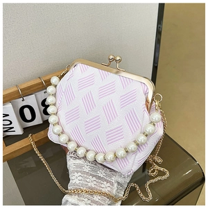 Detail of pink geometric stripe clutch with pearl handle and golden clasp closure