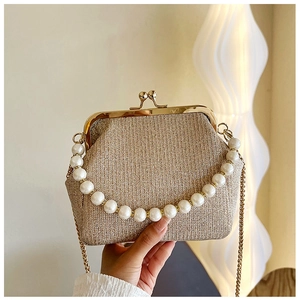 Detail of champagne gold glitter clutch with vintage metal clasp and pearl handle