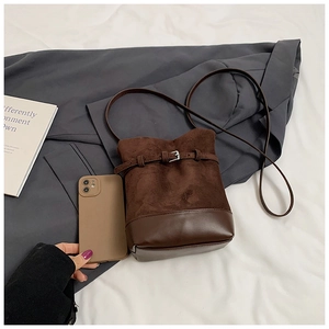 Détails du sac seau marron foncé avec coutures en daim et en cuir lisse élégant