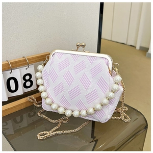 Close-up of pearl handle and pink jacquard fabric on stylish vintage clip bag