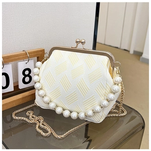Detail of elegant woven mini bag with pearl handle and vintage gold metal clasp