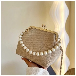 Detail of champagne gold evening clutch with pearl handle and vintage metal kiss lock
