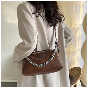 Détail du sac bandoulière marron foncé brillant avec chaîne argentée et zip de fermeture