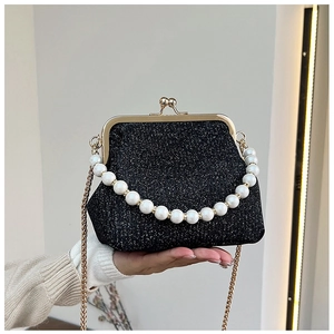 Close-up of black sequin fabric texture with golden metal frame and pearl handle detail