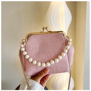 Detail of pink tweed bag featuring elegant pearl handle and vintage gold metal clasp