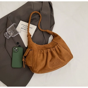 Detail of tan suede tote bag with MKMX logo, side pocket and stylish ruched texture
