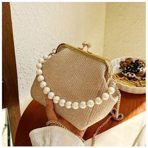 Detail of champagne gold evening clutch with pearl handle and vintage metal frame