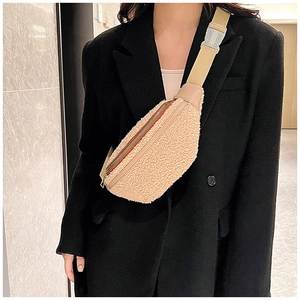 Λεπτομέρεια από μπεζ fleece τσαντάκι μέσης με ρυθμιζόμενο λουράκι πάνω από μαύρο σακάκι