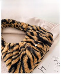Vue détaillée de la texture en fausse fourrure sur un sac bandoulière à zébrures