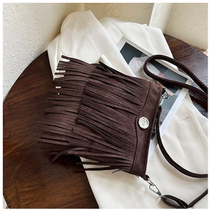 Detailed view of the layered fringes on dark coffee faux suede crossbody bag with metal buckle