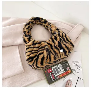 Vue détaillée de dessus du sac en fausse fourrure à motif zèbre sur un manteau rose doux