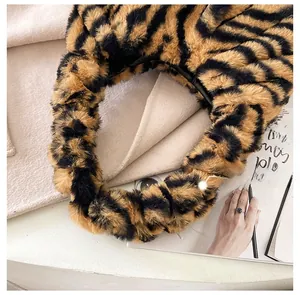 Vue détaillée du sac à main en peluche imprimé tigre jaune avec texture en fausse fourrure