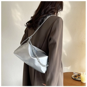 Détail d'un sac à bandoulière argenté métallisé avec lanière en cuir et chaîne en métal épais