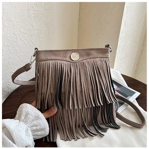 Detailed macro view of retro brown suede fringe crossbody bag with silver buckle