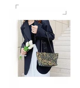 Detail of colorful sequin shoulder bag with metal chain strap in fashion street scene
