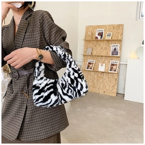Sac bandoulière tendance en fausse fourrure zébrée assorti à un blazer à carreaux chic